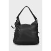 Leather bag decorated with straps