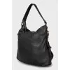 Leather bag decorated with straps