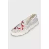 White slip-ons decorated with rhinestones