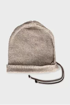 Knitted hat decorated with leather cord