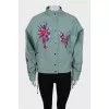 The loose-fitting jacket is decorated with embroidery
