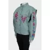 The loose-fitting jacket is decorated with embroidery