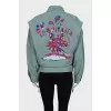 The loose-fitting jacket is decorated with embroidery