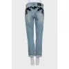The jeans are decorated with mesh and sequins