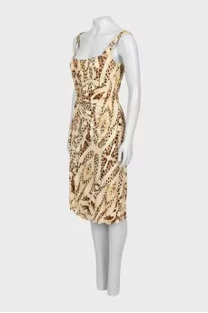 Dress with draping decorated with a brooch