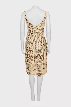 Dress with draping decorated with a brooch