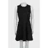 The fitted dress is decorated with tassels