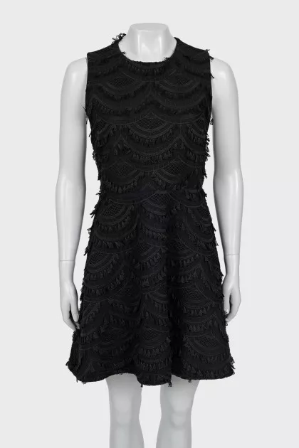 The fitted dress is decorated with tassels
