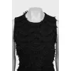 The fitted dress is decorated with tassels