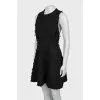 The fitted dress is decorated with tassels