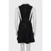The fitted dress is decorated with tassels
