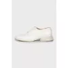 White leather shoes with a figured heel