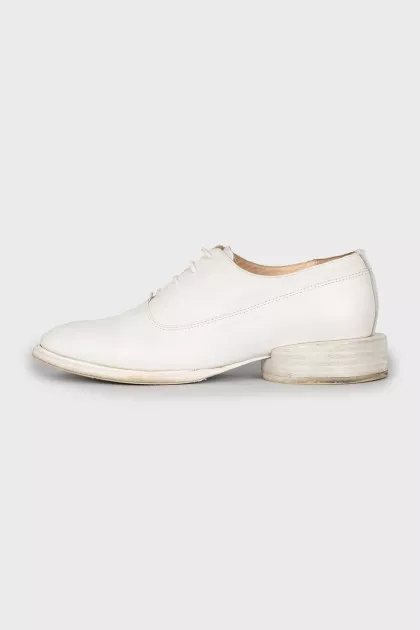 White leather shoes with a figured heel