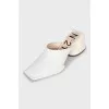 White mules with a figured heel