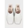 White mules with a figured heel