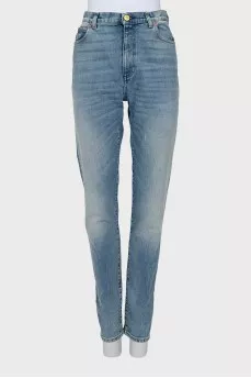 Jeans decorated with embroidered patches