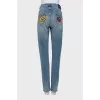 Jeans decorated with embroidered patches