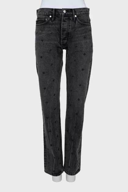 The jeans are decorated with embroidery and a tag