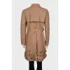 Leather trench coat decorated with flowers