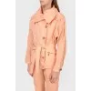 A peach short cloak with an asymmetric fastener on buttons