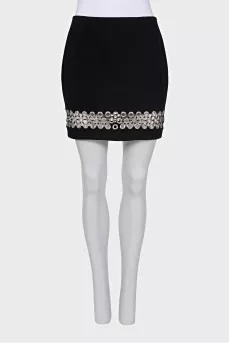 The black skirt is decorated with an eyelet