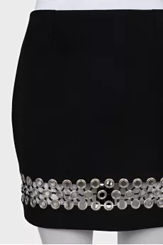 The black skirt is decorated with an eyelet