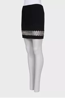 The black skirt is decorated with an eyelet
