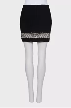 The black skirt is decorated with an eyelet