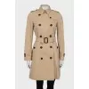 Beige trench coat with branded buttons