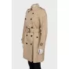 Beige trench coat with branded buttons
