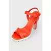 Orange sandals on a white platform