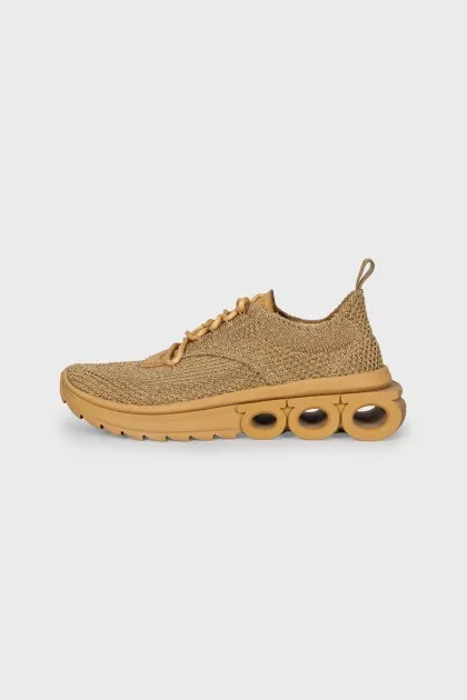 Golden sneakers with a figured sole