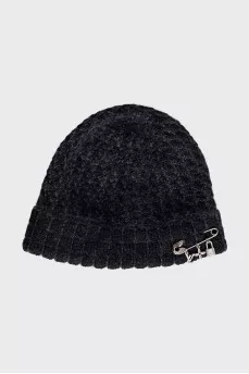 A hat decorated with a pin and pendants