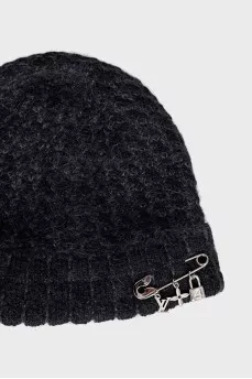 A hat decorated with a pin and pendants