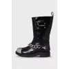 Patent leather boots decorated with a chain