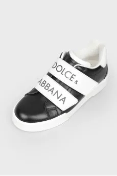 Black children's sneakers with velcro with a tag