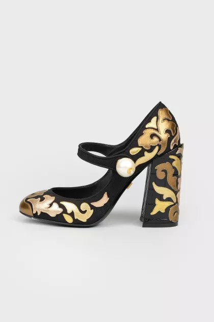 Black and golden shoes with a pearl with a tag