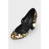 Black and golden shoes with a pearl with a tag