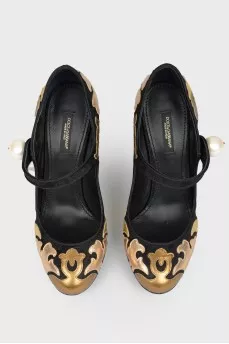 Black and golden shoes with a pearl with a tag