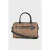 A bag with handles and a strap in a signature print