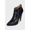 Black leather ankle boots with a slanted heel