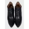 Black leather ankle boots with a slanted heel
