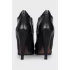 Black leather ankle boots with a slanted heel