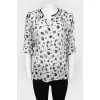 Blouse with a sleeve adjustable in length with a tag