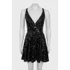 The dress is sleeveless and decorated with sequins