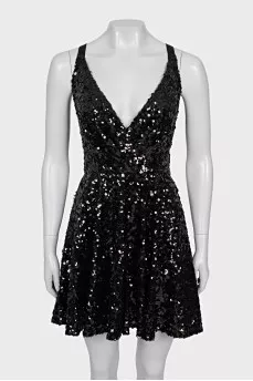 The dress is sleeveless and decorated with sequins
