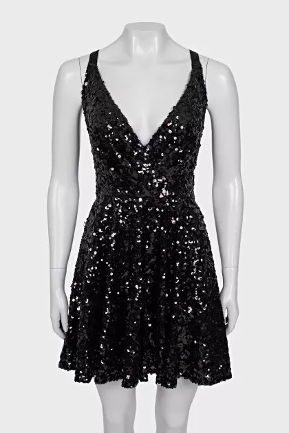 The dress is sleeveless and decorated with sequins
