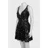 The dress is sleeveless and decorated with sequins
