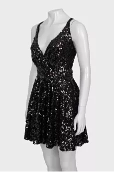 The dress is sleeveless and decorated with sequins