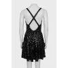 The dress is sleeveless and decorated with sequins
